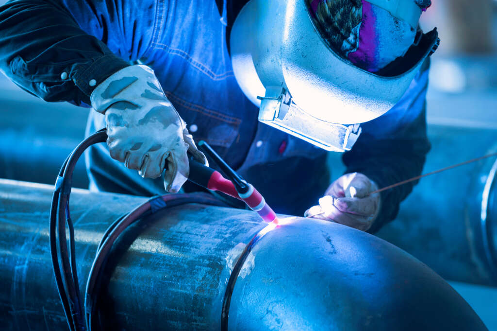 Worker Welding Metal Piping Using Tig Welder